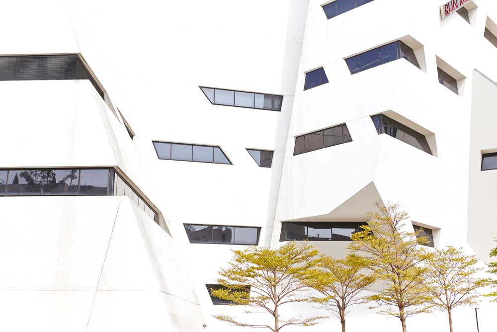 white angular daniel libeskind architect building with trees by airey spaces