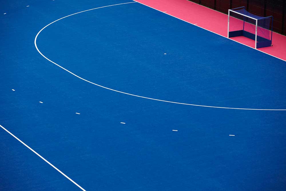 white lines markings and goal on pink and blue hockey pitch at london olympics by airey spaces