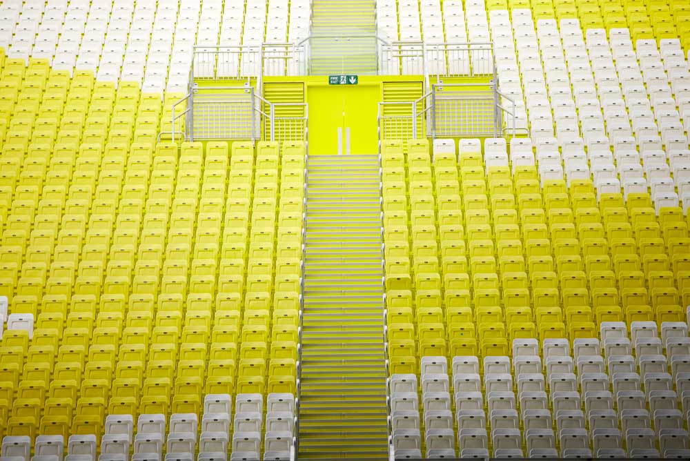 yellow and white plastic seats in london aquatic centre for olympics by airey spaces