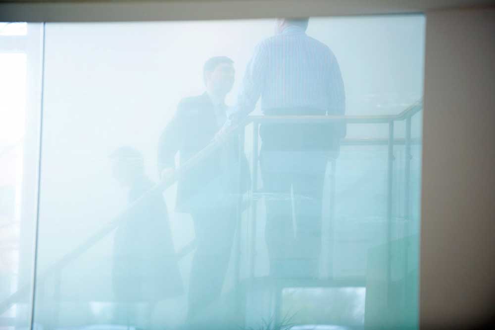 business men meeting on the stairs through frosted glass in office by airey spaces