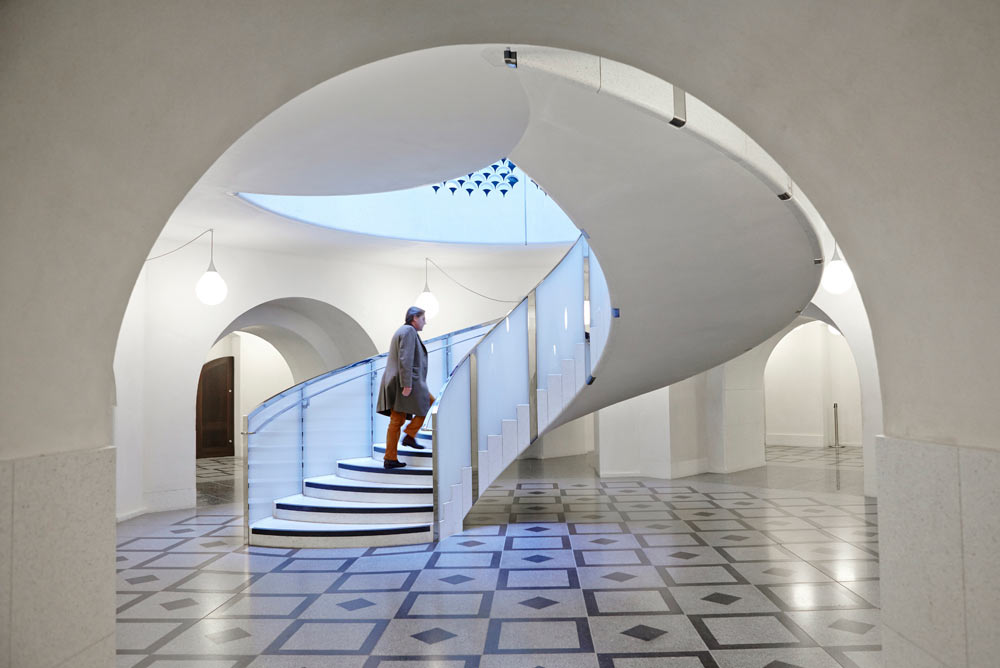 man on spiral staircase in tate britain by airey spaces